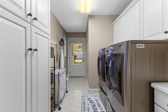 clothes washing area with light tile patterned flooring, cabinets, and independent washer and dryer