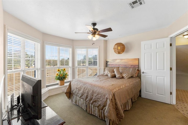 carpeted bedroom with ceiling fan and multiple windows