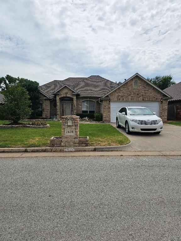 view of front of property featuring a garage and a front lawn