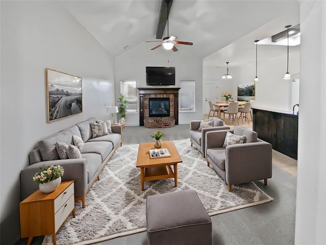 living room with ceiling fan, a fireplace, beamed ceiling, and high vaulted ceiling