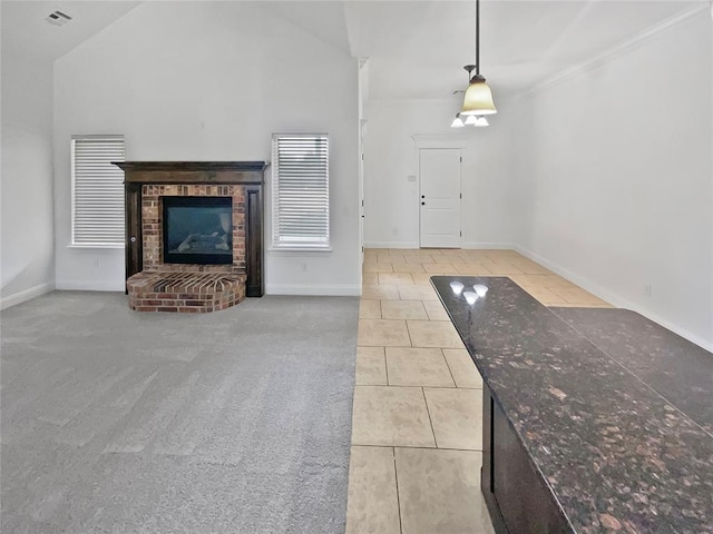 unfurnished living room with ornamental molding, a fireplace, light carpet, and vaulted ceiling