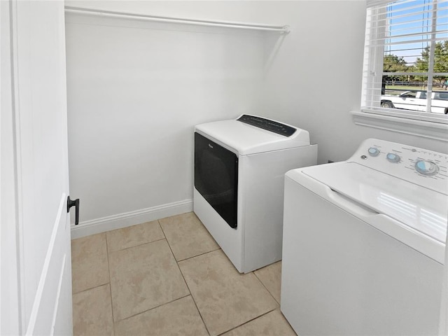 laundry area featuring washer and dryer and light tile patterned floors