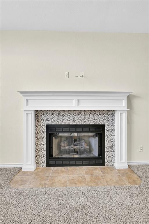 interior details with a tile fireplace and carpet floors