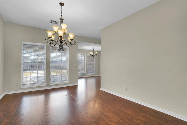 516 S Quail Run, Altus, OK 73521 - unfurnished room featuring a chandelier and dark wood-type flooring