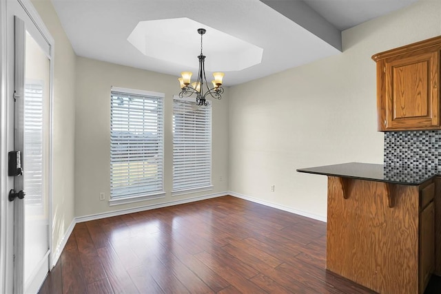 516 S Quail Run, Altus, OK 73521 - unfurnished dining area with a chandelier and dark wood-style floors