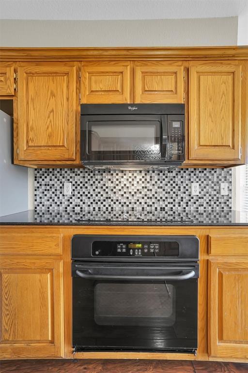 kitchen with black appliances and tasteful backsplash