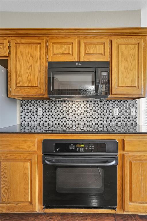516 S Quail Run, Altus, OK 73521 - kitchen with black appliances, dark countertops, backsplash, and brown cabinetry