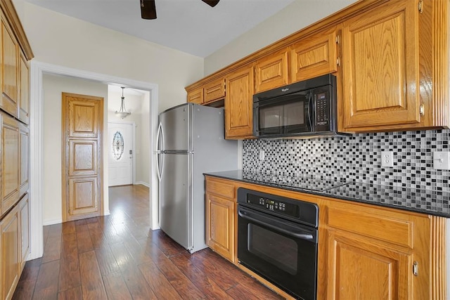 kitchen featuring black appliances, ceiling fan, dark stone countertops, tasteful backsplash, and dark hardwood / wood-style flooring