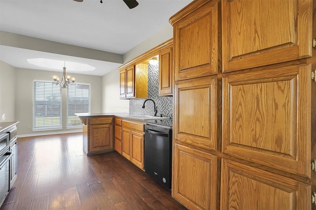 516 S Quail Run, Altus, OK 73521 - kitchen with black dishwasher, dark wood-style floors, a peninsula, a chandelier, and brown cabinets