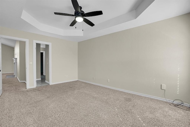 516 S Quail Run, Altus, OK 73521 - empty room featuring a raised ceiling, light colored carpet, and a ceiling fan
