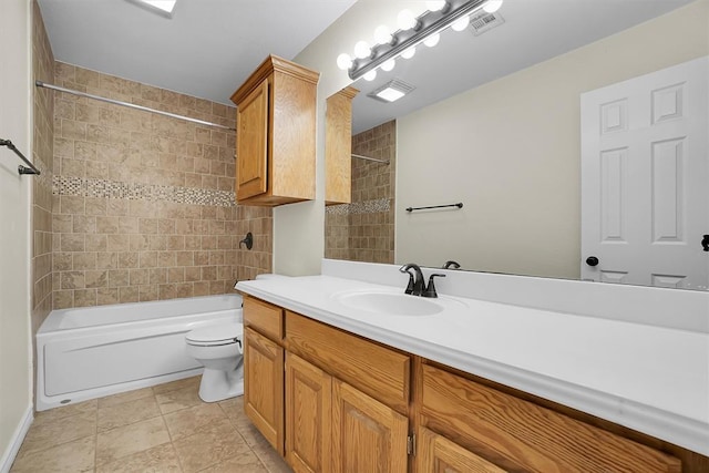 full bathroom with tile patterned floors, tiled shower / bath combo, toilet, and vanity