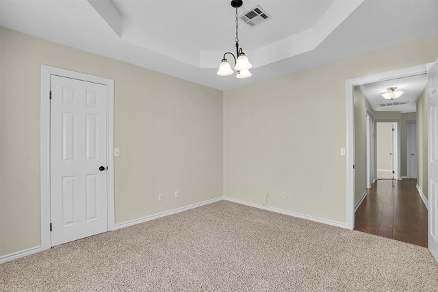 516 S Quail Run, Altus, OK 73521 - unfurnished room featuring a chandelier, dark colored carpet, and a tray ceiling