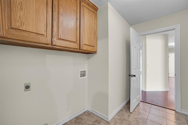 clothes washing area with cabinets, light tile patterned floors, washer hookup, and hookup for an electric dryer