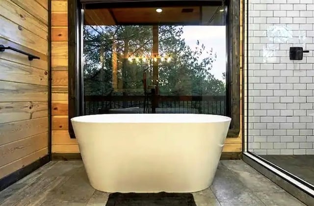 bathroom with a bathtub and wooden walls