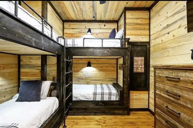 bedroom with wood walls, wood-type flooring, and wooden ceiling