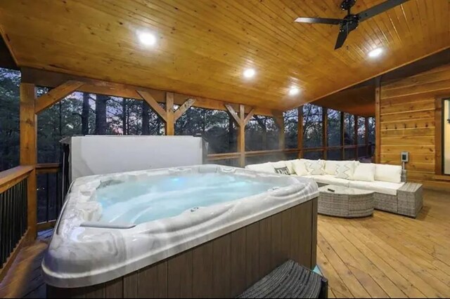 deck with ceiling fan, an outdoor living space, and a hot tub