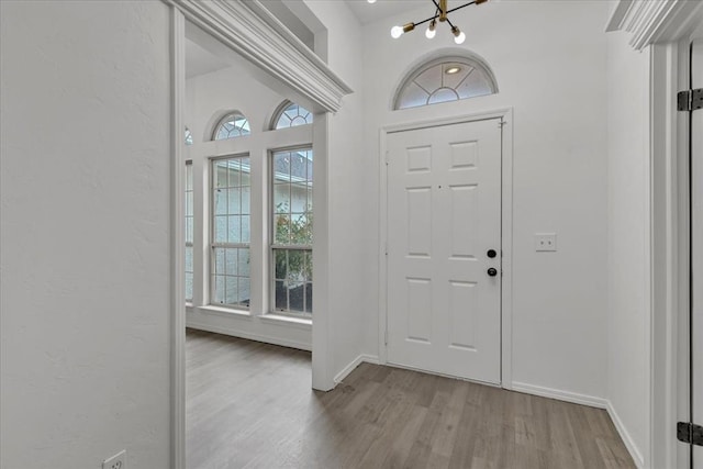 foyer entrance featuring a wealth of natural light, a chandelier, and light wood-type flooring