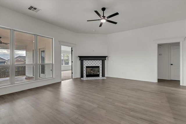 unfurnished living room with ceiling fan, hardwood / wood-style floors, and a fireplace