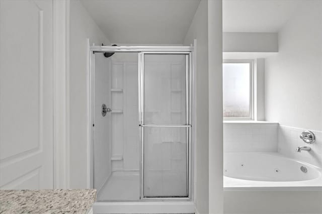 bathroom featuring shower with separate bathtub