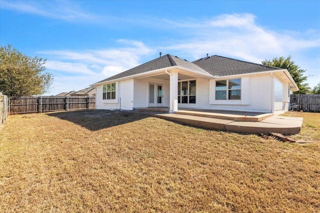 rear view of property with a lawn and a patio