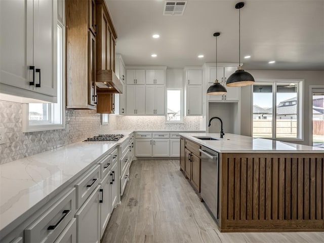 kitchen with a healthy amount of sunlight, white cabinetry, sink, and appliances with stainless steel finishes