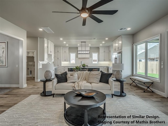 living room featuring light hardwood / wood-style floors and ceiling fan