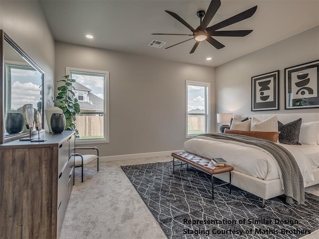 carpeted bedroom featuring ceiling fan and multiple windows