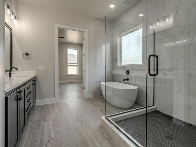 bathroom featuring hardwood / wood-style floors, vanity, and independent shower and bath