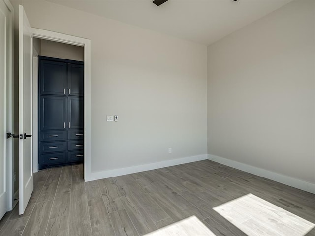 unfurnished bedroom with ceiling fan, light hardwood / wood-style floors, and a closet