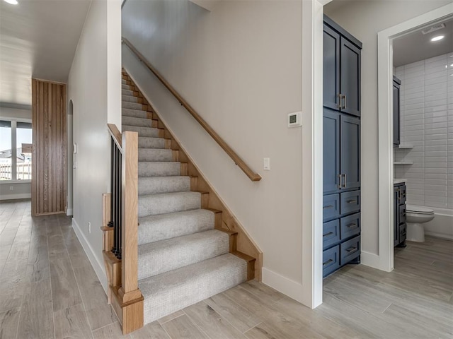 stairs featuring hardwood / wood-style floors