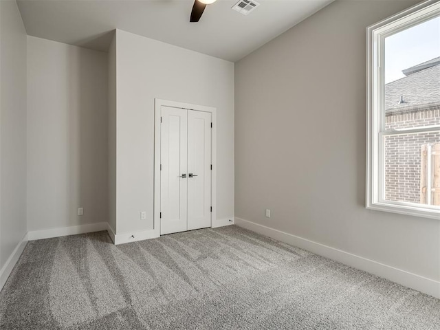 unfurnished bedroom featuring carpet floors, ceiling fan, and a closet