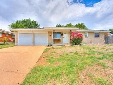 single story home featuring a garage and a front yard