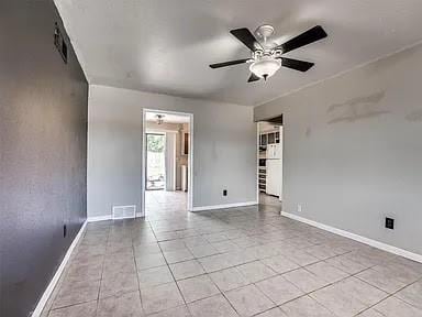 tiled empty room featuring ceiling fan