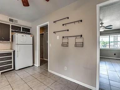 kitchen featuring ceiling fan, light tile patterned floors, and white refrigerator