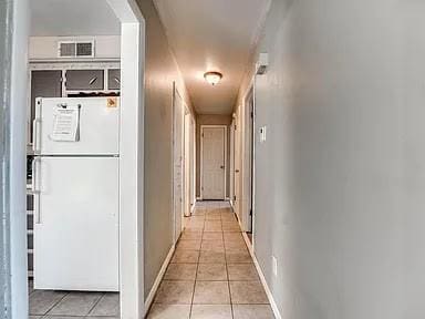 hall with light tile patterned floors