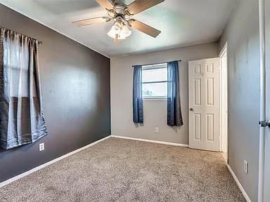 empty room featuring carpet flooring and ceiling fan