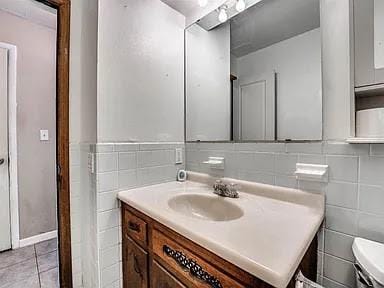 bathroom with tile patterned flooring, vanity, toilet, and tile walls