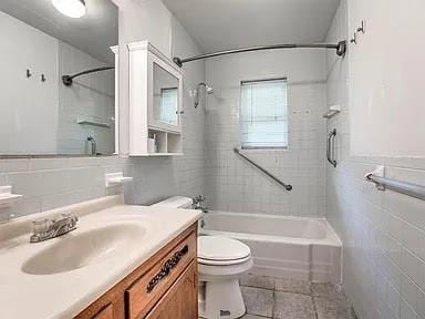 full bathroom featuring tile patterned flooring, vanity, tile walls, and toilet