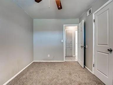 unfurnished bedroom with ceiling fan and light colored carpet