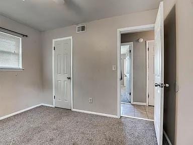 unfurnished bedroom featuring light carpet