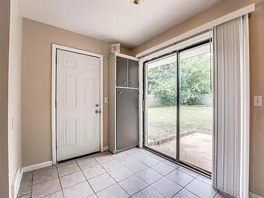 doorway to outside with light tile patterned floors