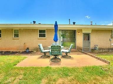 back of property with a yard and a patio