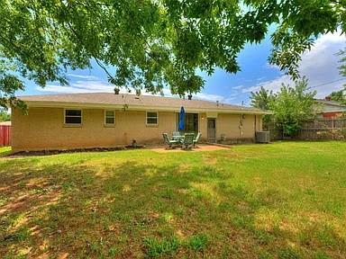 rear view of house featuring a lawn