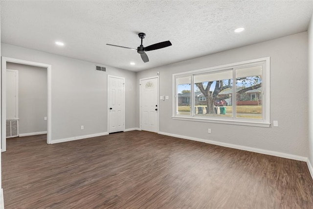 empty room featuring a textured ceiling, dark hardwood / wood-style floors, and ceiling fan