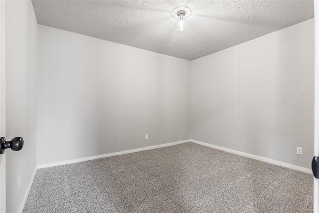 empty room with carpet floors and a textured ceiling