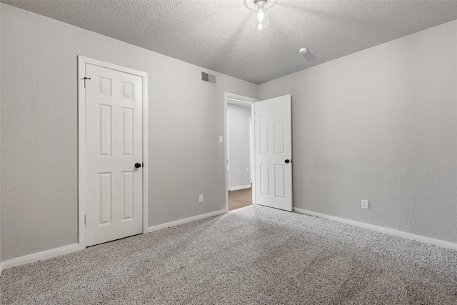 unfurnished bedroom featuring carpet flooring and a textured ceiling