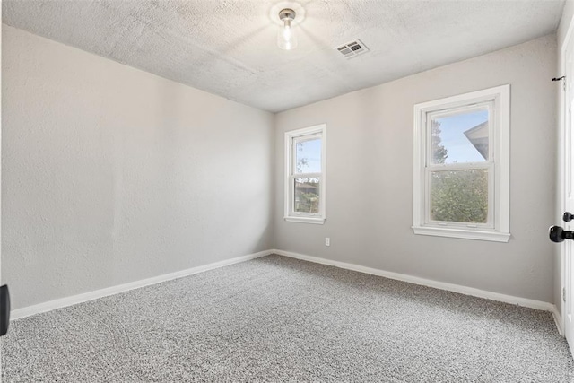 carpeted spare room with a textured ceiling