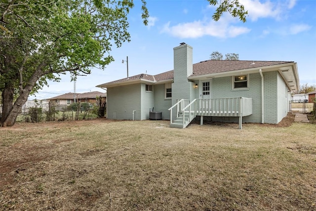 back of property with a yard, central AC unit, and a deck