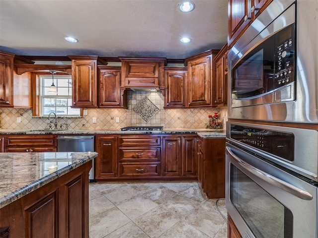 kitchen with appliances with stainless steel finishes, backsplash, light stone counters, and sink