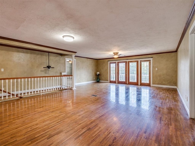 empty room featuring hardwood / wood-style flooring, ceiling fan, ornamental molding, and a textured ceiling